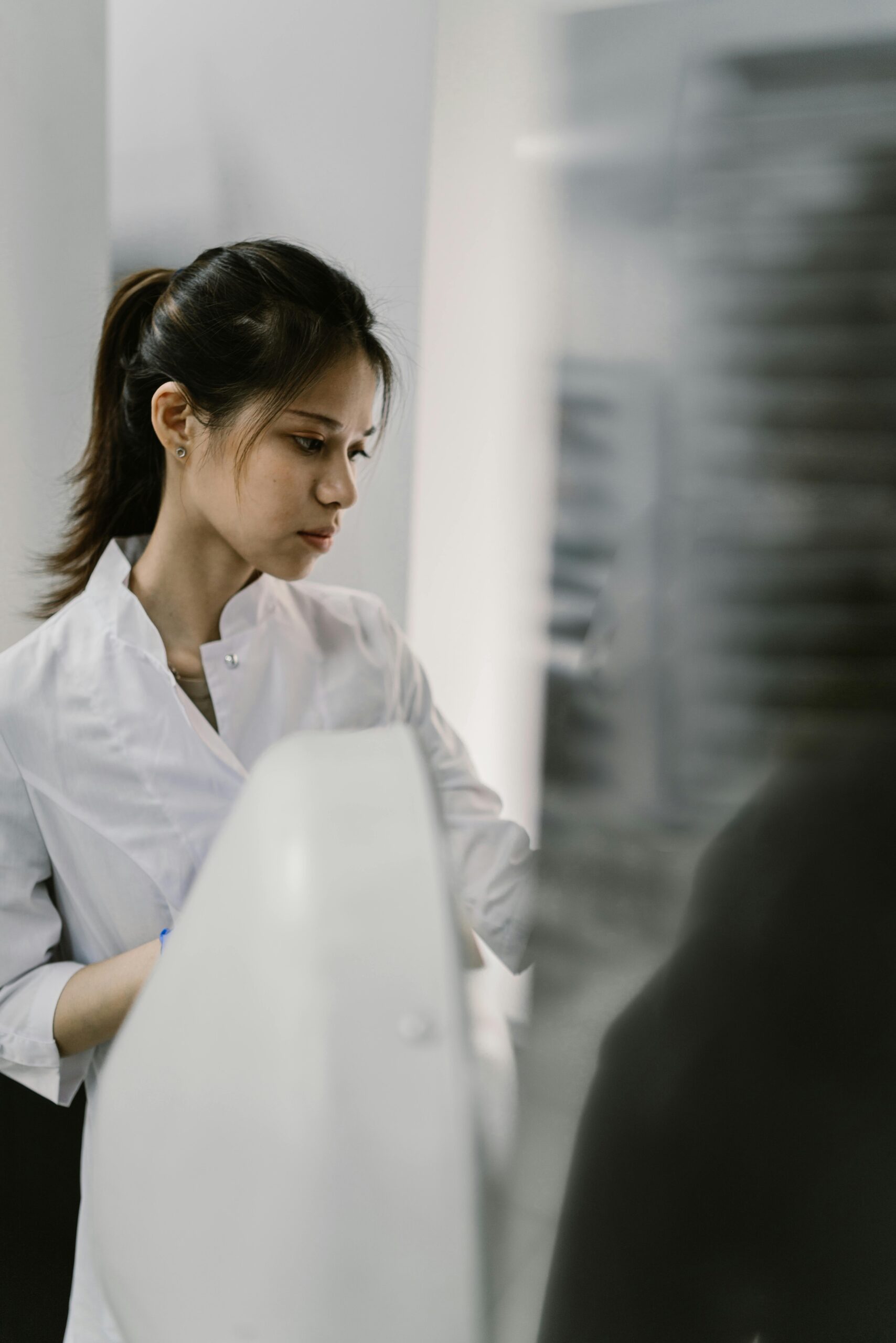 Young female scientist in a laboratory wearing a white lab coat, focused on work.